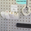 Four USB charging adapters stored on a white pegboard holder with a 25 mm hole center spacing label.
