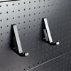 Two black keyboard support brackets mounted on a round-hole pegboard