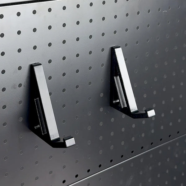 Two black keyboard support brackets mounted on a round-hole pegboard