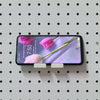 White KOKO Pegboard phone holder supporting a smartphone horizontally on a round-hole pegboard.