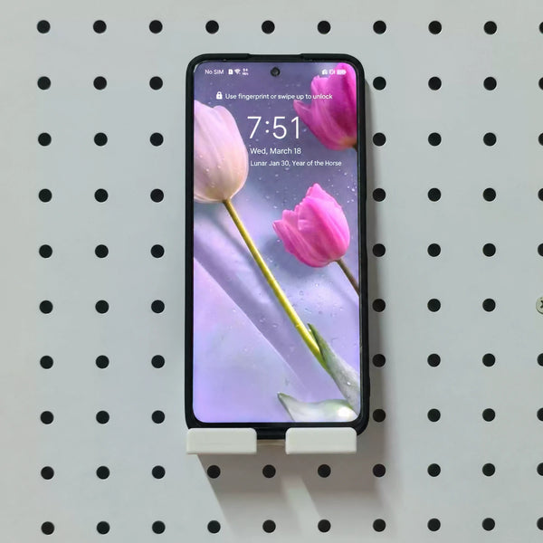 White KOKO Pegboard phone holder supporting a smartphone vertically on a round-hole pegboard.