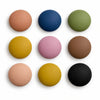 Nine round photo magnets in muted colors arranged in a three-by-three grid on a white background.