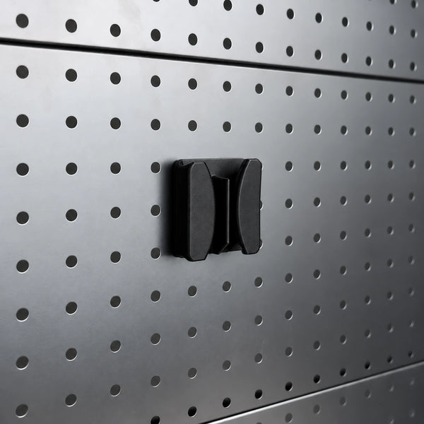 Black KOKO single-cable holder mounted on a gray round-hole pegboard, showing its empty center channel and curved side supports.